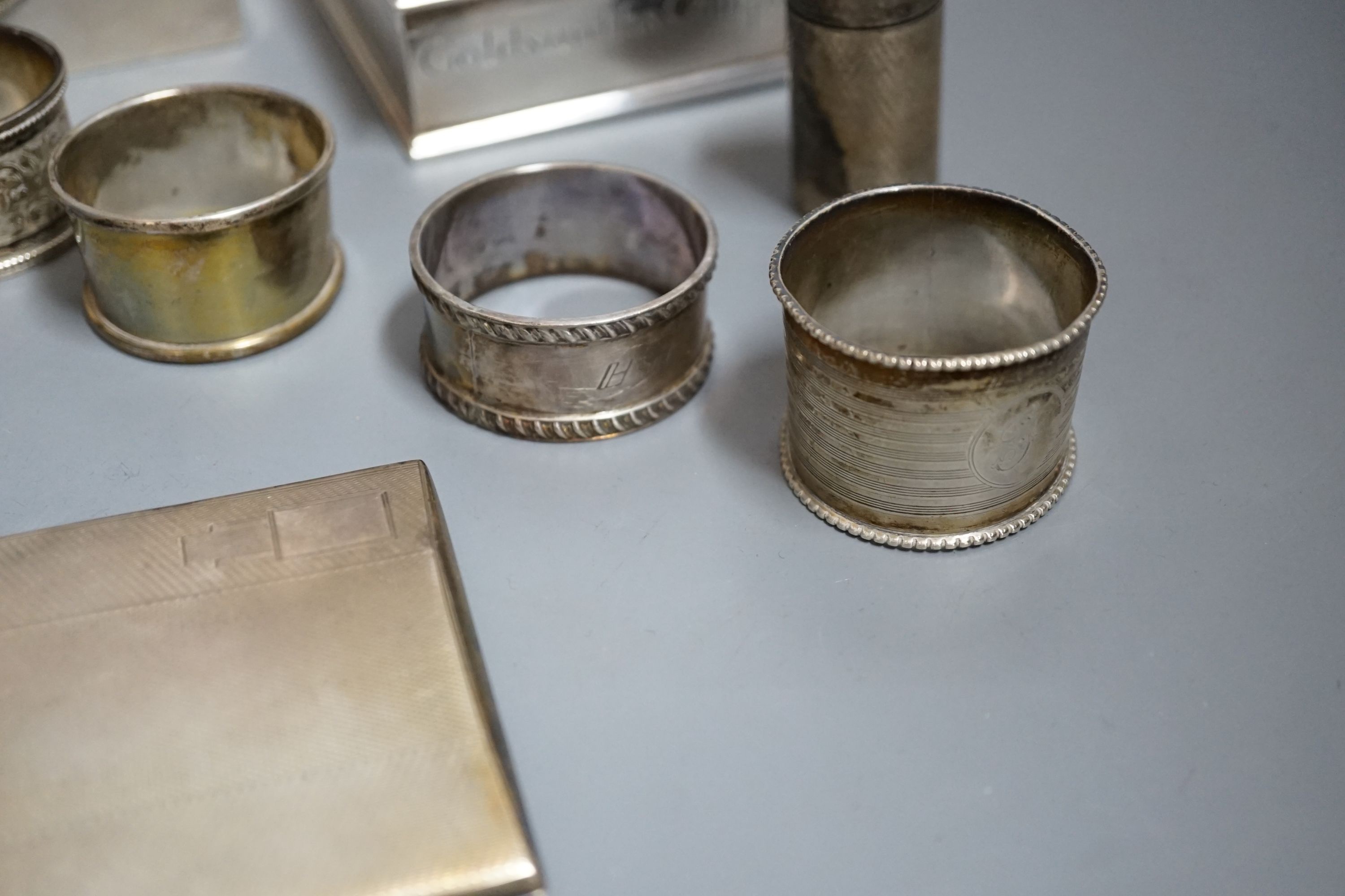 Sundry silver items including a George V 'The Gift of the Goldsmiths Company' box by Garrard & Co, London, 1926, 92mm, a silver cigarette case and box, four silver napkin rings, a cased silver christening trio and a silv